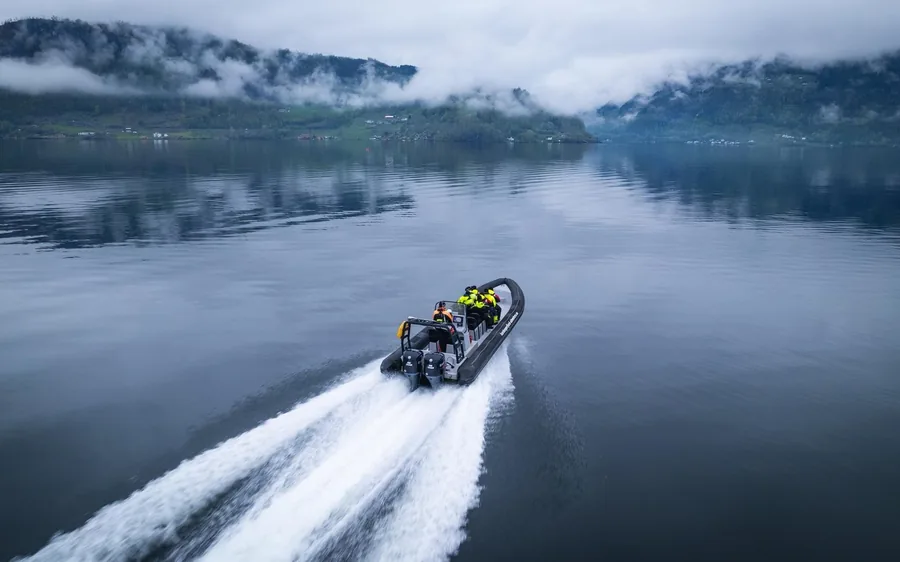 A RIB boat at speed in a narrow arm of the Hardangerfjord